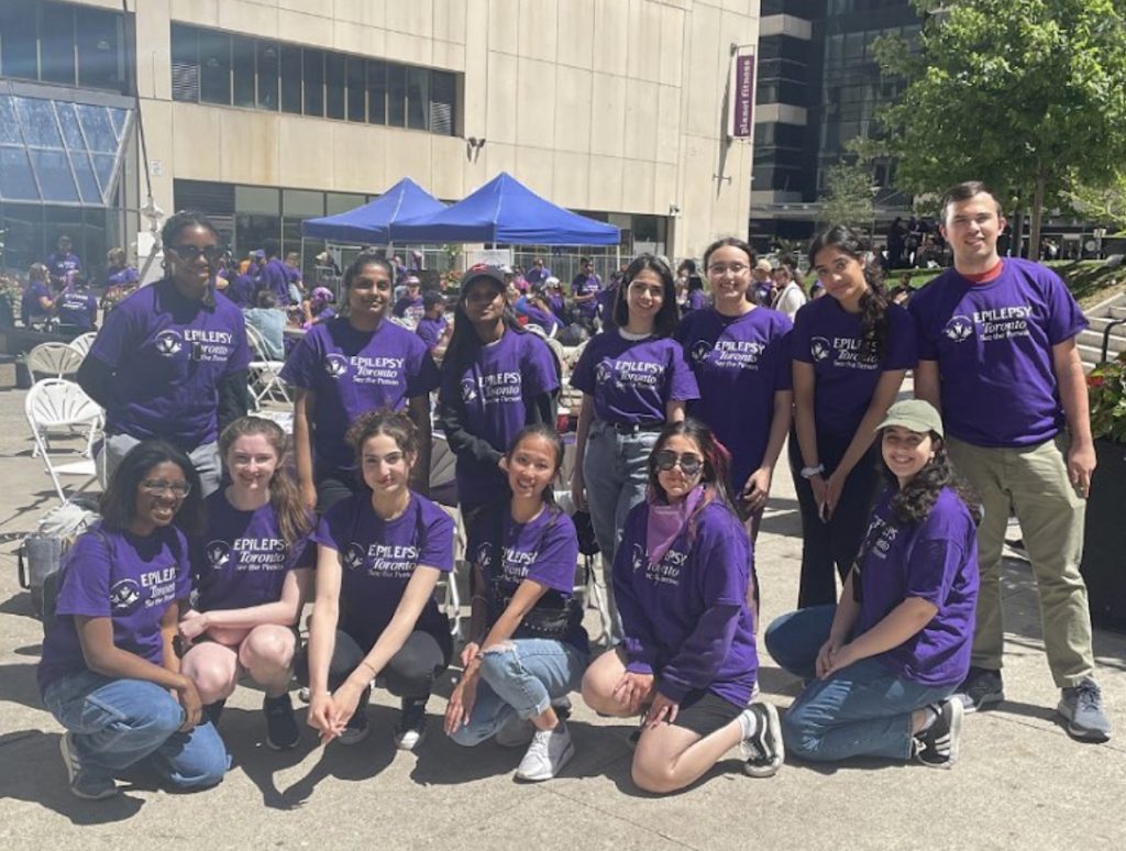 13 students, including Catherine, wearing Epilepsy Toronto t-shirts and smiling for a group photo.